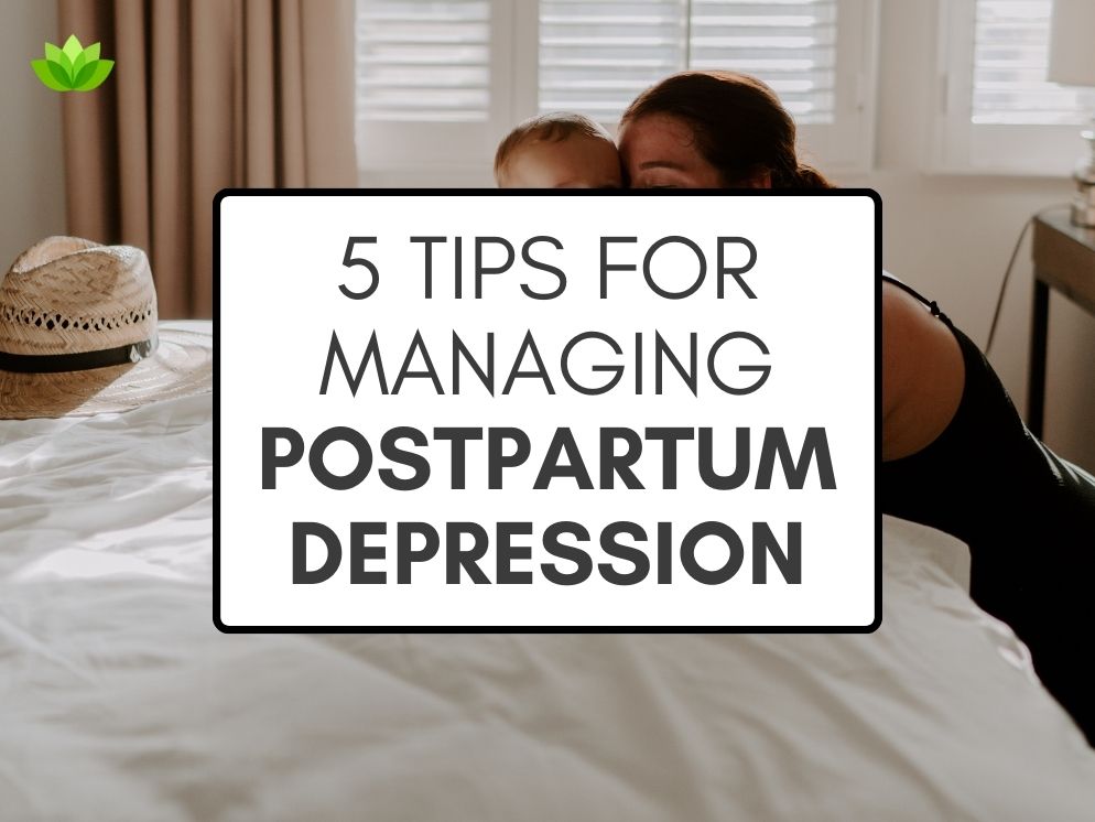 "5 Tips For Managing Postpartum Depression" in black text inside a white text box with a black border, over a stock photo of a woman kneeling in front of a window next to a bed made up with white linens, leaning her head against the head of her small baby, who is sitting up at the end of the bed.