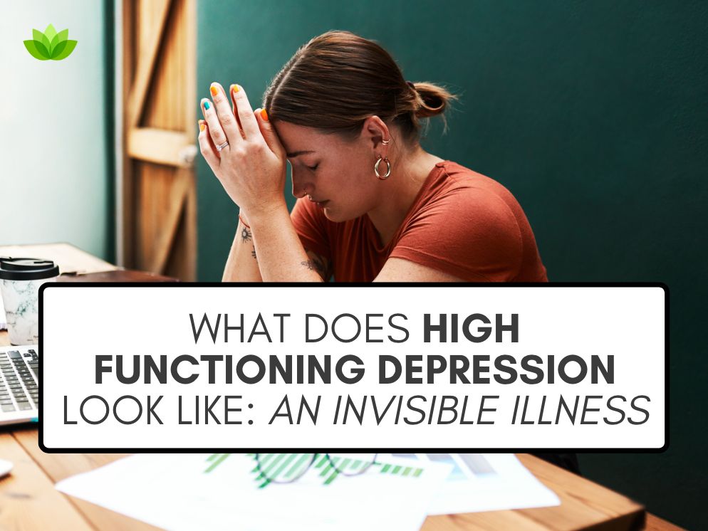 A graphic that reads "What Does High Functioning Depression Look Like- An Invisible Illness" over a stock photo of a white woman sitting at a large wooden table surrounded by papers and a calculator, with her head resting on her hands as if she is overwhelmed. The wall behind her is painted a deep green.