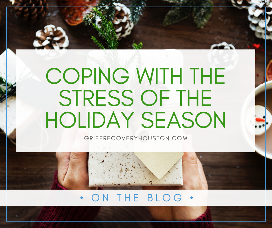 A graphic that reads "Coping with the Stress of the Holiday Season" in green text on a partially transparent white rectangle, over a stock photo of hands holding a wrapped present over a table with pine cones that have been painted to look snow covered.
